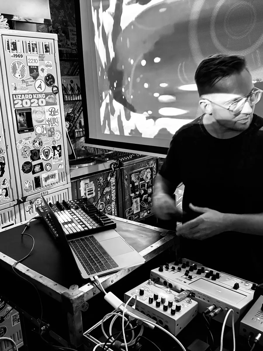 The composer performing a live set on hardware synths, sampler, and laptop